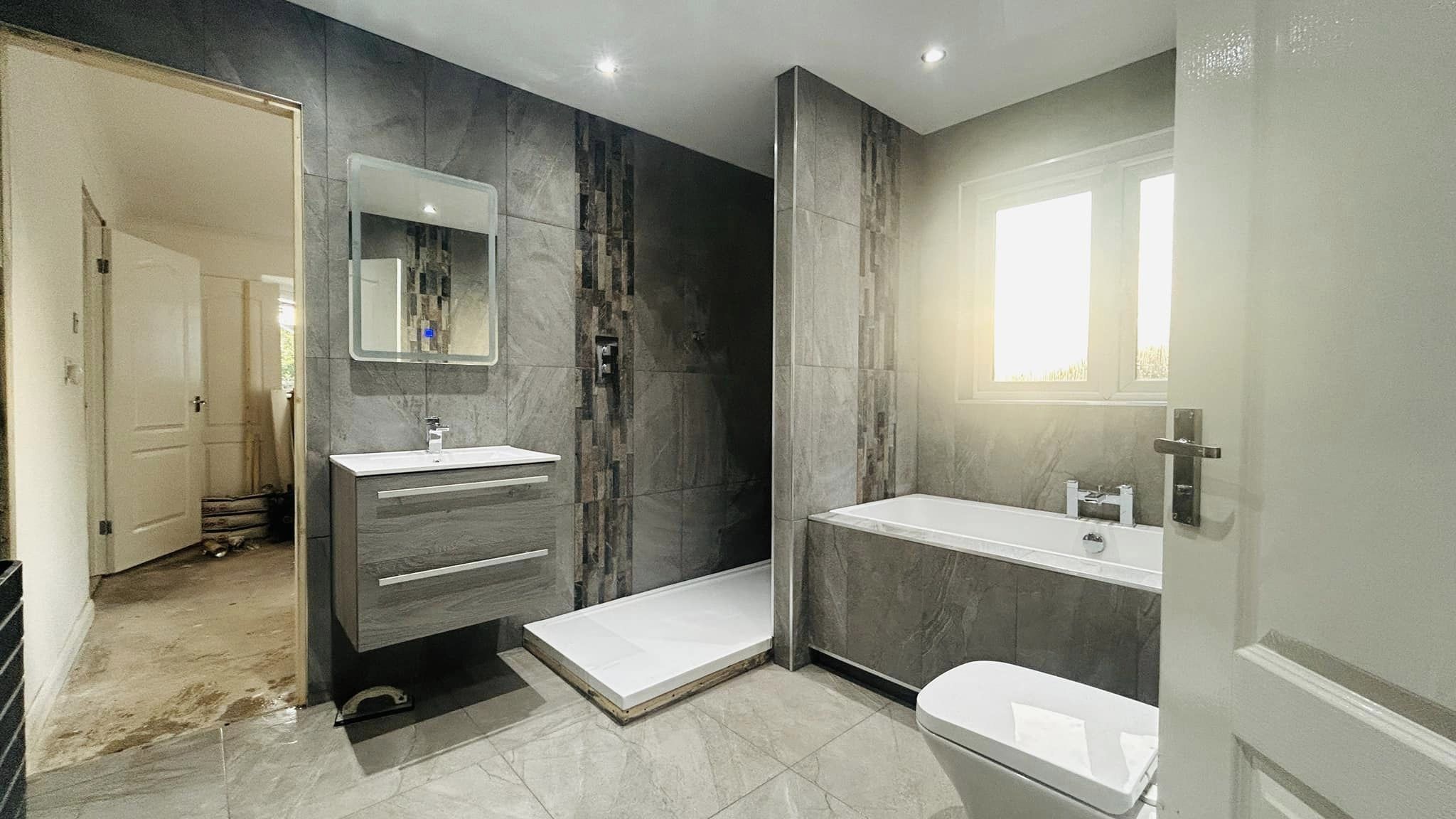 bathroom with walk-in shower and bathtub and stone-look tiles